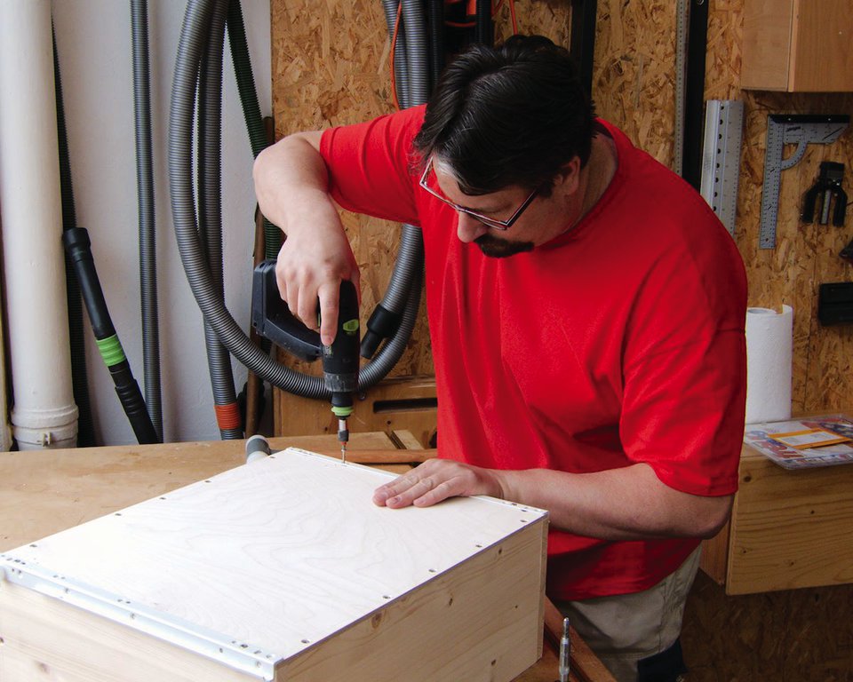 Die unteren Schienen des Auszuges werden an die Schubkästen geschraubt.