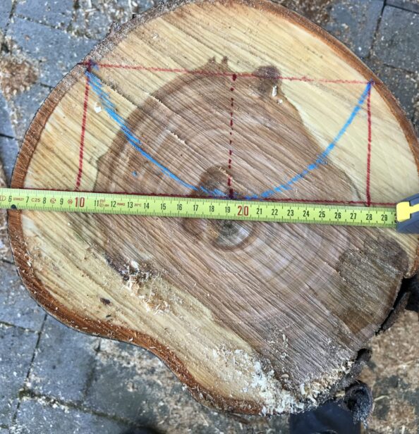 Die ungefähre Position des Werkstücks im Stamm wird mit einem Maßband und Markierungsstrichen ausgemessen.